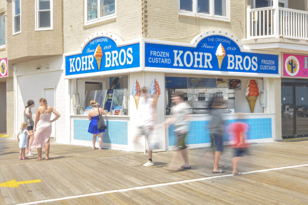 People walking on the boardwalk in front of an ice cream shop