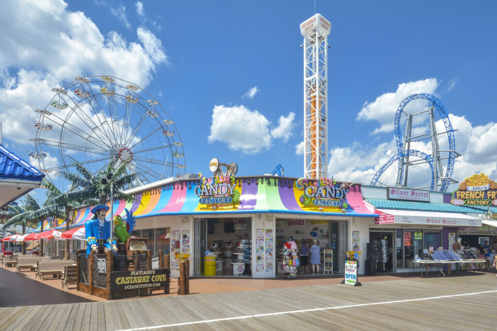Colorful storefront with a Ferris wheel and rides behind it